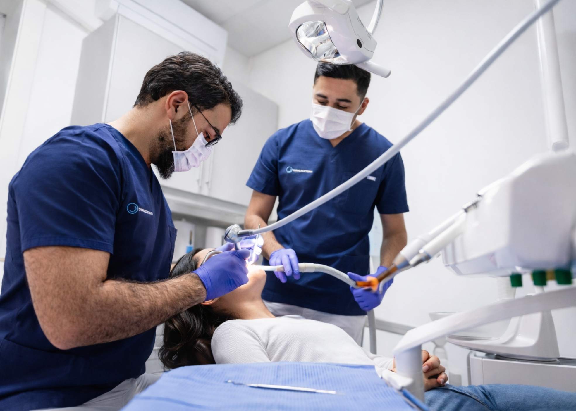 To tannleger behandler pasient i tannlegestol under akutt konsultasjon