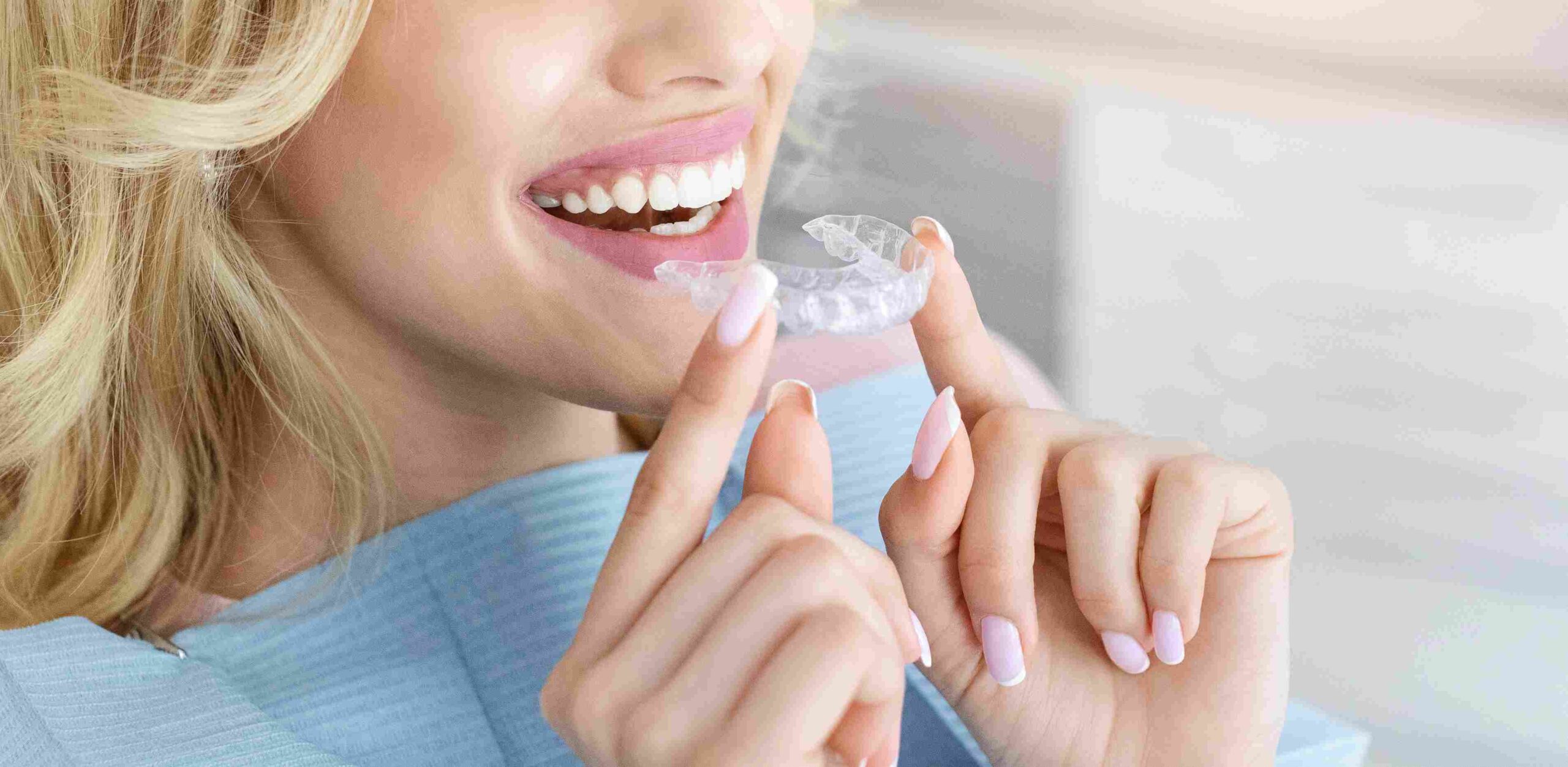 Kvinne som setter inn en Invisalign-skinne og smiler, illustrerer behandlingsvarighet.